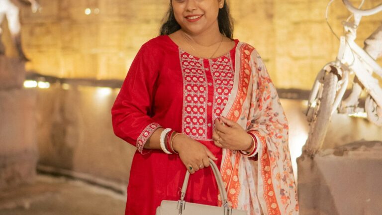 Pakistani shopper in red traditional attire holding a handbag